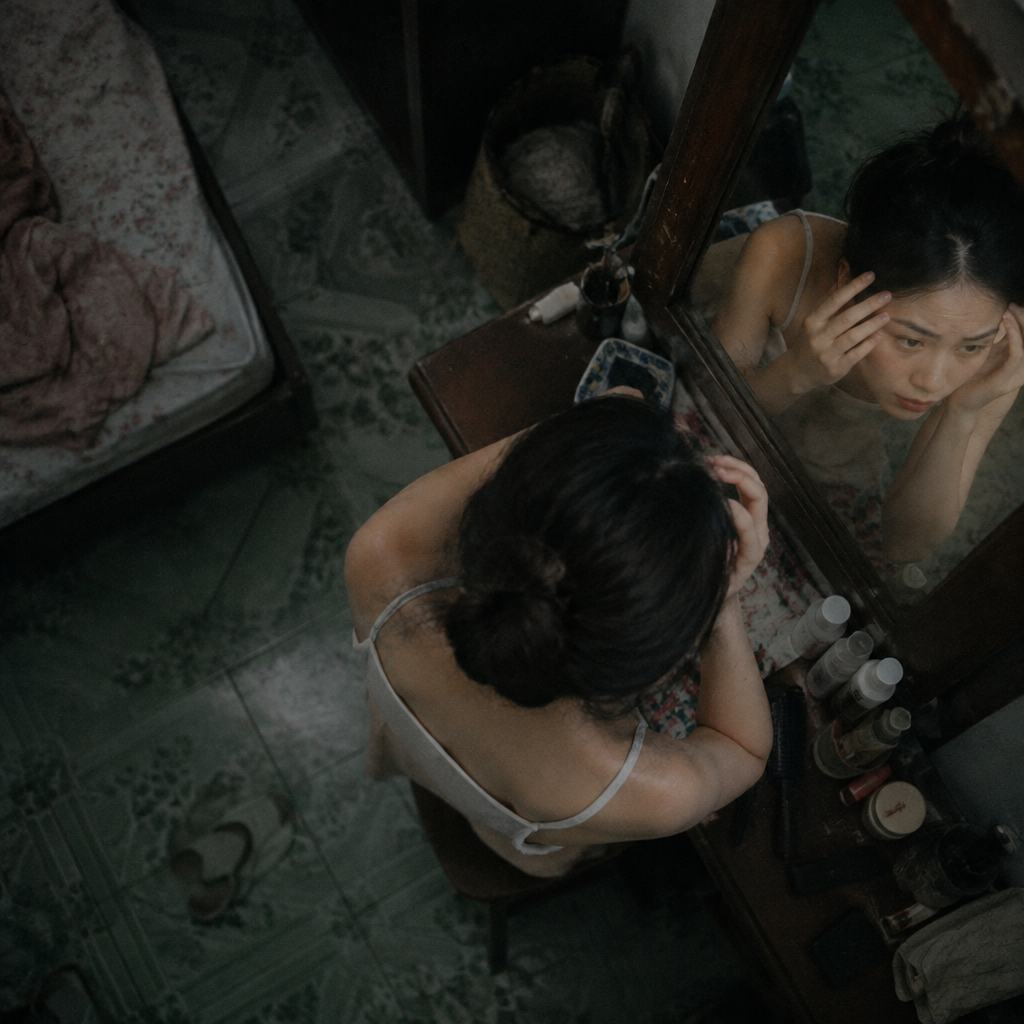 Người phụ nữ trung niên nhìn vào gương với vẻ lo lắng về dấu hiệu lão hóa.